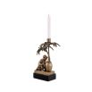 A charming brass candle holder with a decorative monkey and palm tree on a granite base.
