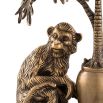 A charming brass candle holder with a decorative monkey and palm tree on a granite base.
