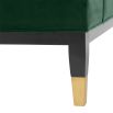 green velvet upholstered deep-buttoned sofa with black legs and brass accents 