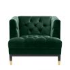 green velvet upholstered deep-buttoned chair with black legs and gold accents 