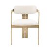 A chic and contemporary brushed brass dining chair upholstered in boucle fabric 