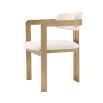 A chic and contemporary brushed brass dining chair upholstered in boucle fabric 