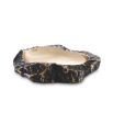 A luxurious rugged bronze bowl with a smooth, polished brass interior