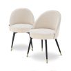 A set of Mid-Century Modern dining chairs with a luxurious upholstery, tapered black legs and brass caps