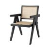 An iconic, black Jeanneret-inspired dining chair with a rattan seat and backrest