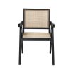 An iconic, black Jeanneret-inspired dining chair with a rattan seat and backrest