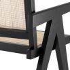 An iconic, black Jeanneret-inspired dining chair with a rattan seat and backrest