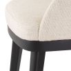 A luxurious dining chair by Eichholtz with a Pausa Natural upholstery and sleek black tapered legs 