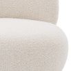 A luxurious boucle armchair with a brushed brass swivel base