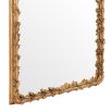 An elaborate vintage brass wall mirror with intricate leaf detailing