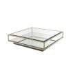 A contemporary glass coffee table with a brushed brass finish