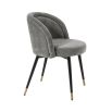 A luxurious set of two velvet dining chairs with black tapered legs and golden caps