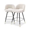 A luxury set of counter stools by Eichholtz with sumptuous upholstery and brass capped feet