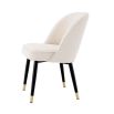 Stunning upholstered chair with black tapered legs and brass caps. 