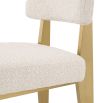 A luxurious modern brushed brass and boucle dining chair 