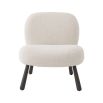 A luxurious boucle cream armchair with splayed, wooden legs