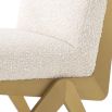 A luxurious boucle and brushed brass dining chair