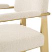 A luxurious brushed brass and boucle dining chair with arms 