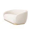 A sumptuous art deco inspired sofa with a brushed brass swivel base