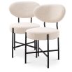 Set of 2 mid-century modern style dining chairs, upholstered in boucle cream with black metal legs.