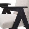 A classic shaped dining chair with contrasting black legs and white boucle upholstery