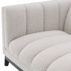 A cosy and luxurious boucle cream sofa with a contrasting black finish base by Eichholtz 