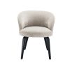 A stylish dining chair by Eichholtz with a beige upholstery, curved back and black tapered legs