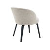 A stylish dining chair by Eichholtz with a beige upholstery, curved back and black tapered legs