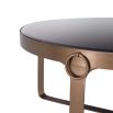 An industrial décor inspired coffee table in a copper finish and a black glass top.