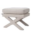 A luxurious boucle cream ottoman with x-shaped legs