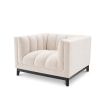 A luxurious boucle armchair in a creamy white upholstery with black legs
