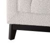 A luxurious boucle armchair in a creamy white upholstery with black legs