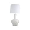 A stylish table lamp by Eichholtz with a white porcelain base featuring relief patterns, a crystal glass plinth and off-white fabric shade