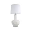 A stylish table lamp by Eichholtz with a white porcelain base featuring relief patterns, a crystal glass plinth and off-white fabric shade