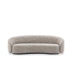 Curved sofa upholstered in a beige fabric.