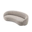 Curved sofa upholstered in a beige fabric.