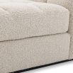 Middle sofa section upholstered in a boucle cream fabric with a black base.