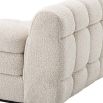 A right facing sofa upholstered in a boucle fabric mounted on a black base.