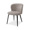 A divine dining chair by Eichholtz with a beautiful beige upholstery, black tapered black legs and an arched back
