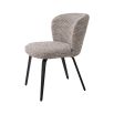 A divine dining chair by Eichholtz with a beautiful beige upholstery, black tapered black legs and an arched back