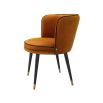 A luxurious orange velvet dining chair with a swivel seat, black legs and gold capped feet 