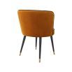 A luxurious orange velvet dining chair with a swivel seat, black legs and gold capped feet 