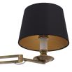 A decadent wall lamp with a black shade and vintage brass finish 