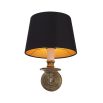 A decadent wall lamp with a black shade and vintage brass finish 