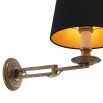 A decadent wall lamp with a black shade and vintage brass finish 