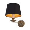 A decadent wall lamp with a black shade and vintage brass finish 