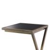 A stylish side table by Eichholtz with a cross-legged frame, vintage brass finish and black glass table top