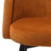 A luxury set of dining chairs with an orange velvet upholstery and golden capped feet