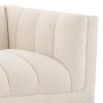 A luxurious lounge sofa by Eichholtz with a bouclé cream upholstery, deep channel stitching and a black base