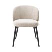 A luxury set of dining chairs from Eichholtz with a beige upholstery and tapered black legs